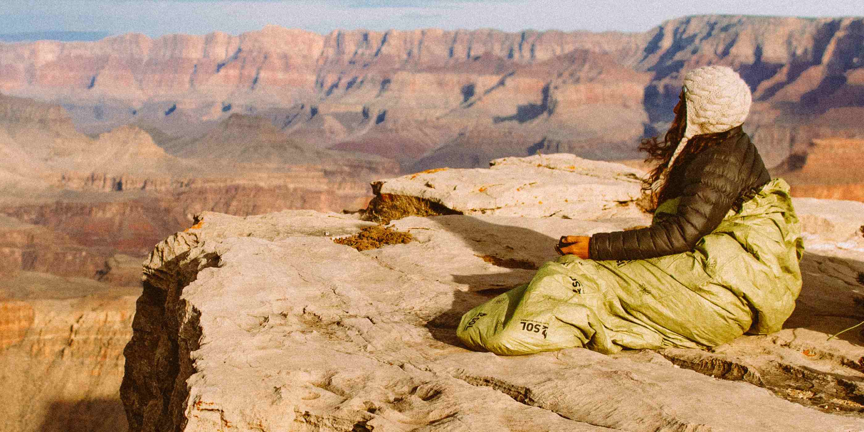 Woman Sitting in Emergency Bivvy OD Green on Grand Canyon