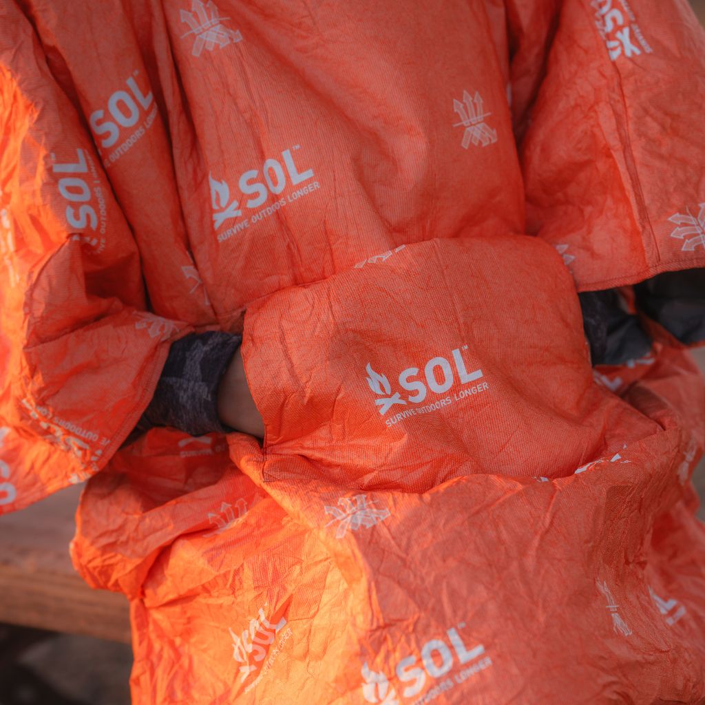 Escape Insulated Poncho hands in handwarmer pockets close up