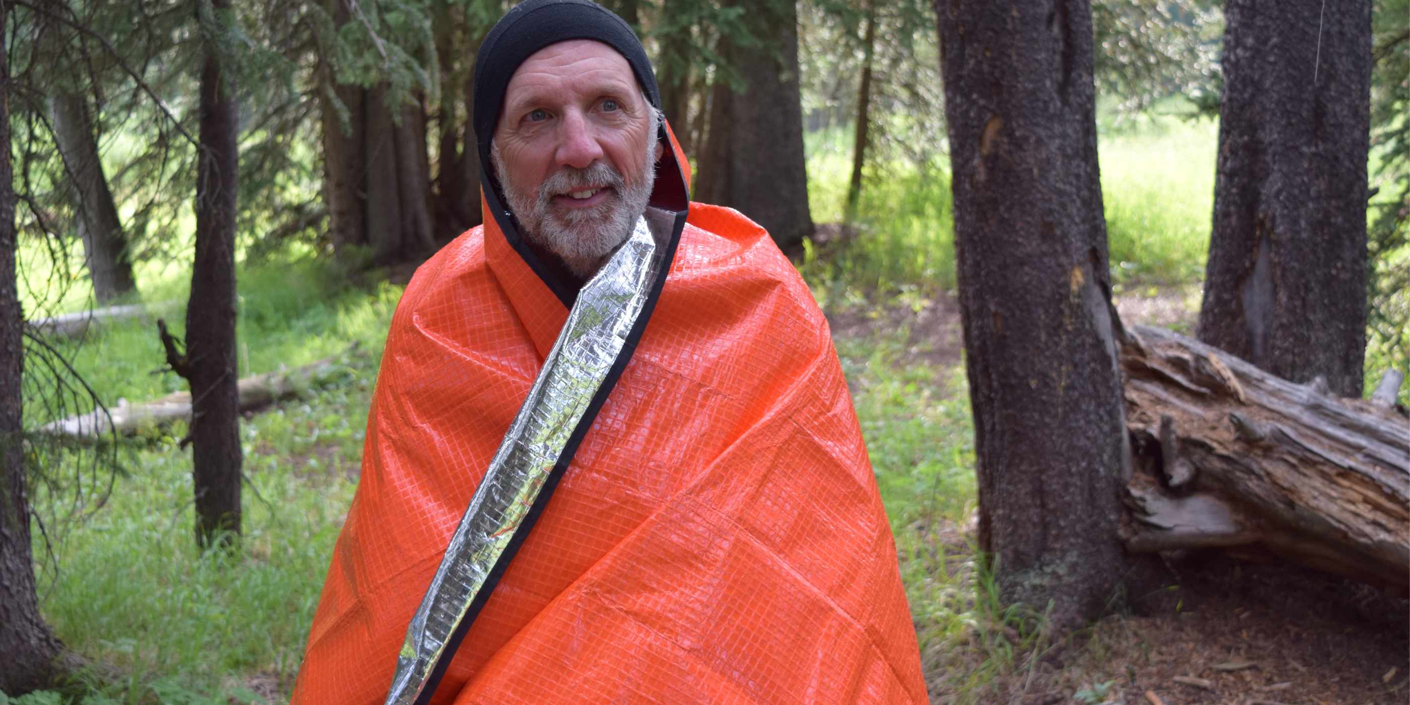 Man Wrapped in SOL All Season Blanket in Woods