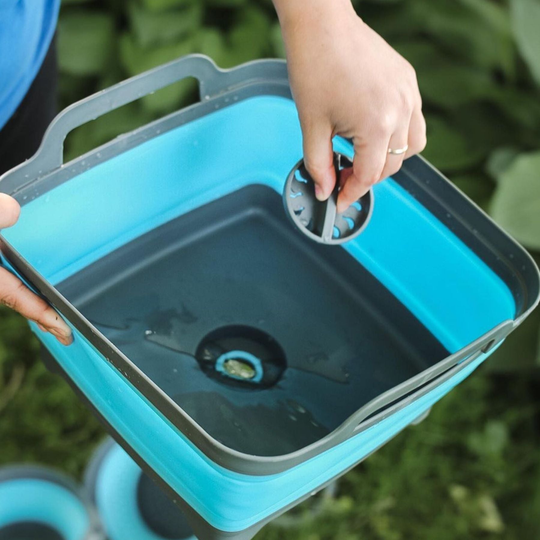 Pulling Drain Out of Blue and Gray Flat Pack Collapsible Sink 8L