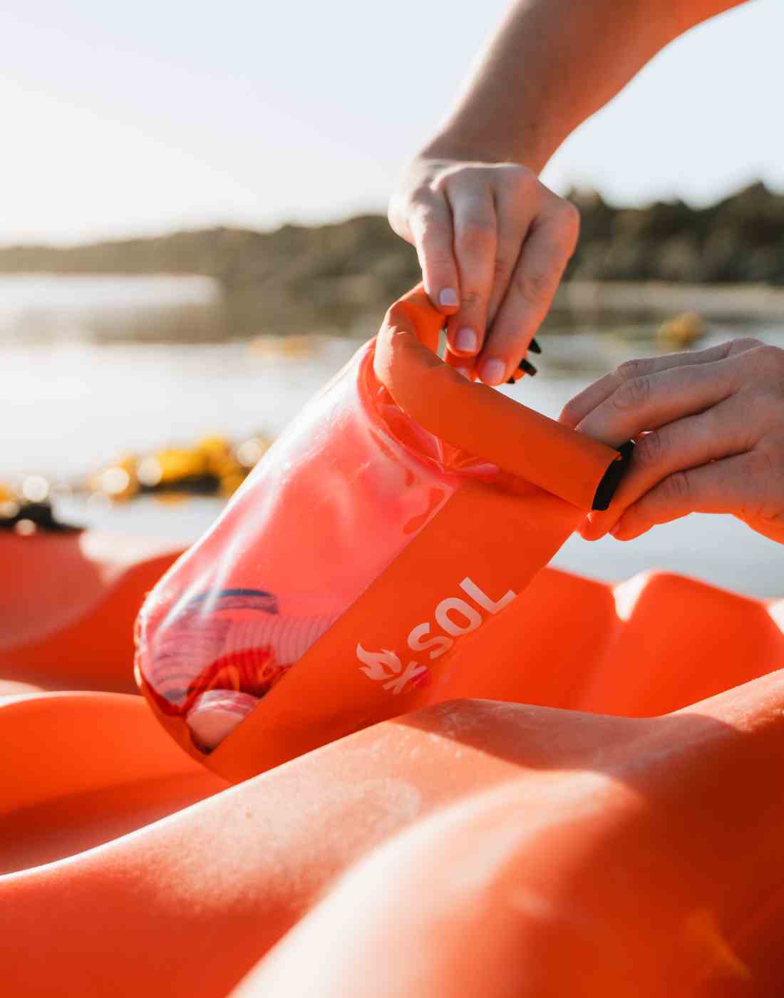 Pulling Items from SOL Emergency Kit on Kayak on Lake