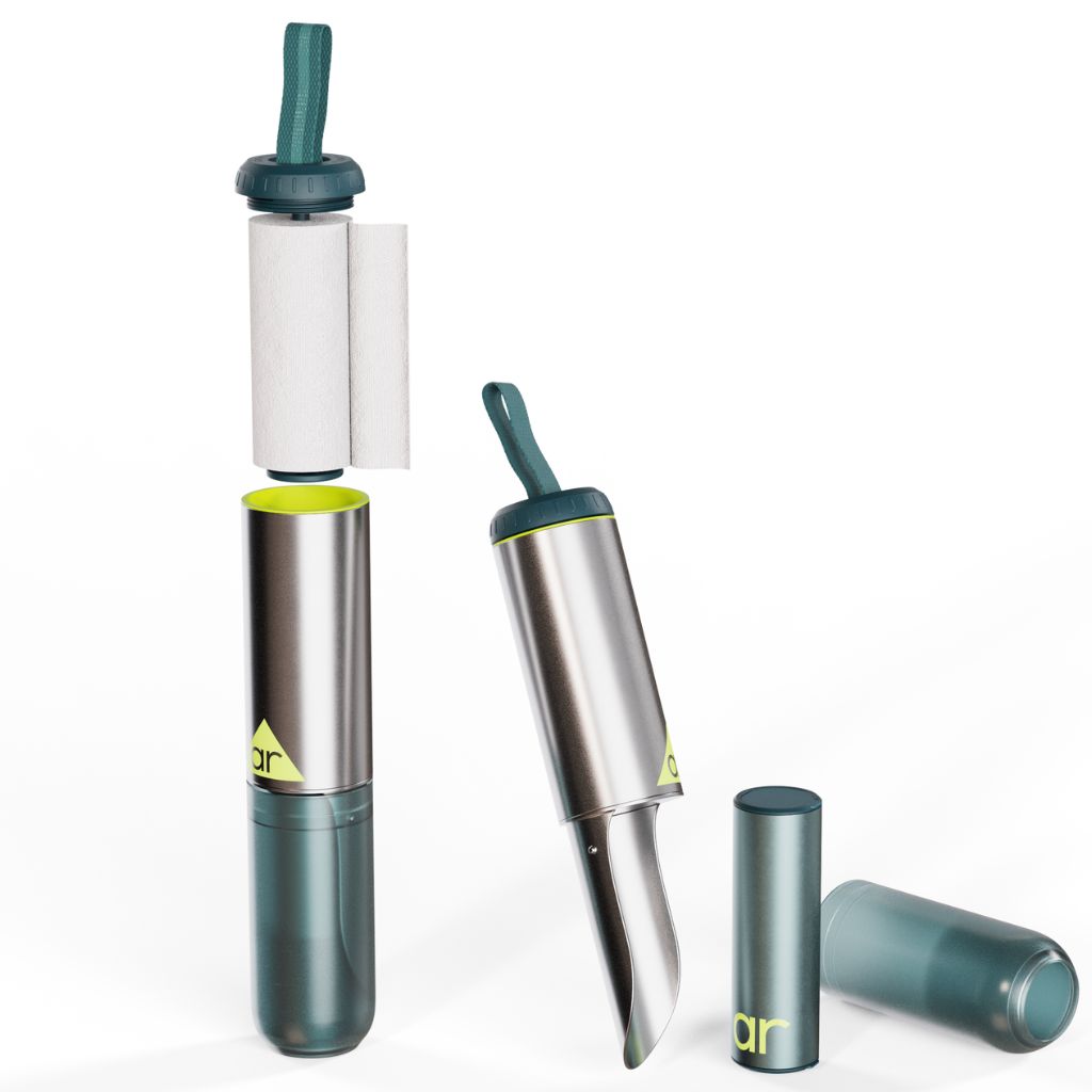 The image shows a trowel toilet kit with a spool of toilet paper, a green and silver trowel, and two gray capsules designed for hand washing.