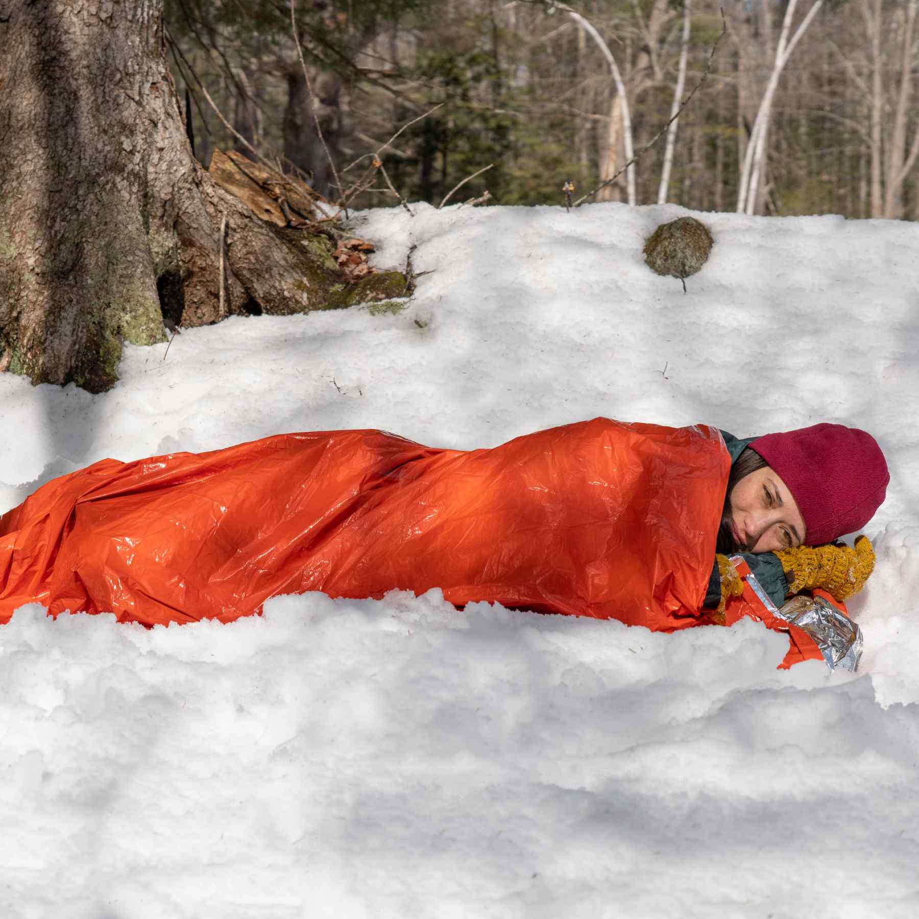 Emergency Bivvy with Rescue Whistle - Orange woman in bivvy laying on snow