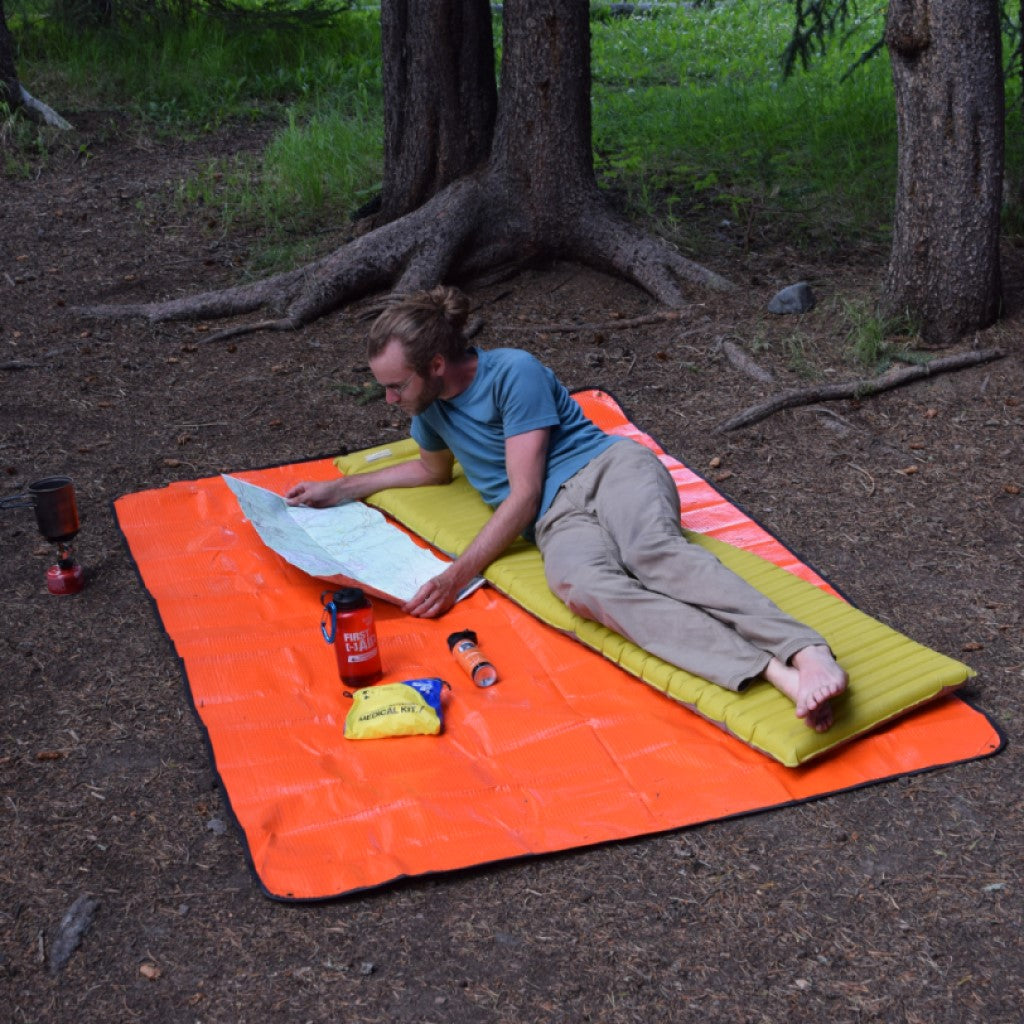 All Season Blanket man laying on blanket in woods reading map