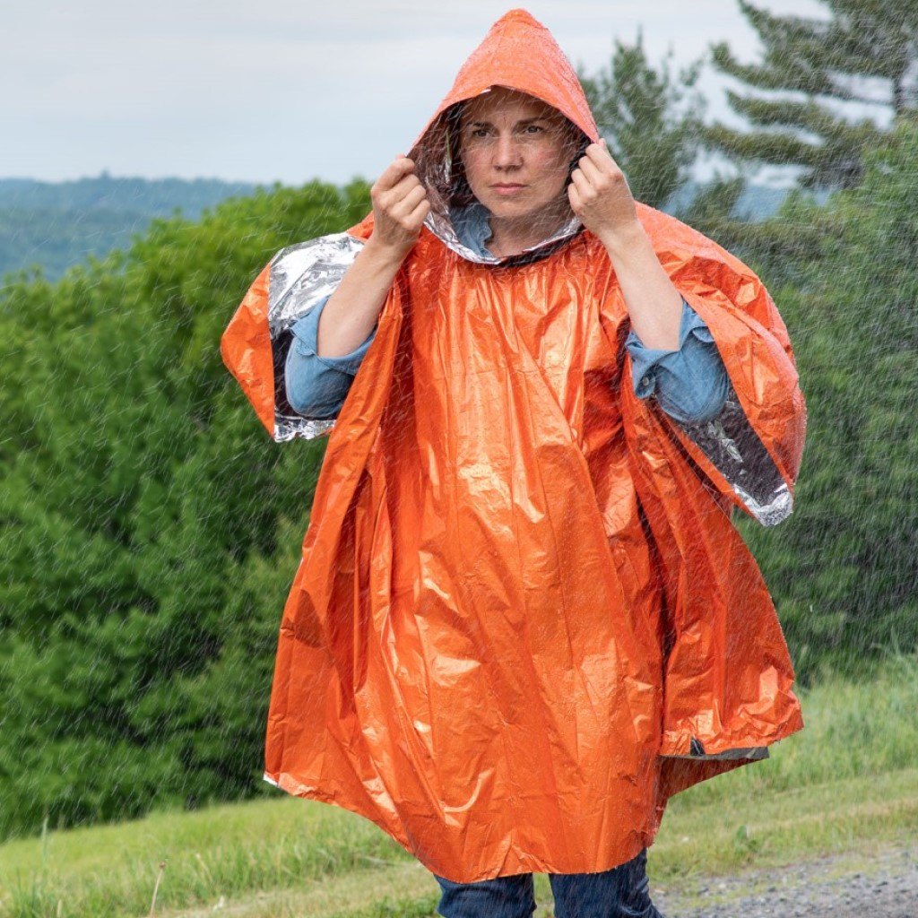 Heat Reflective Poncho woman putting on hood of poncho in rain