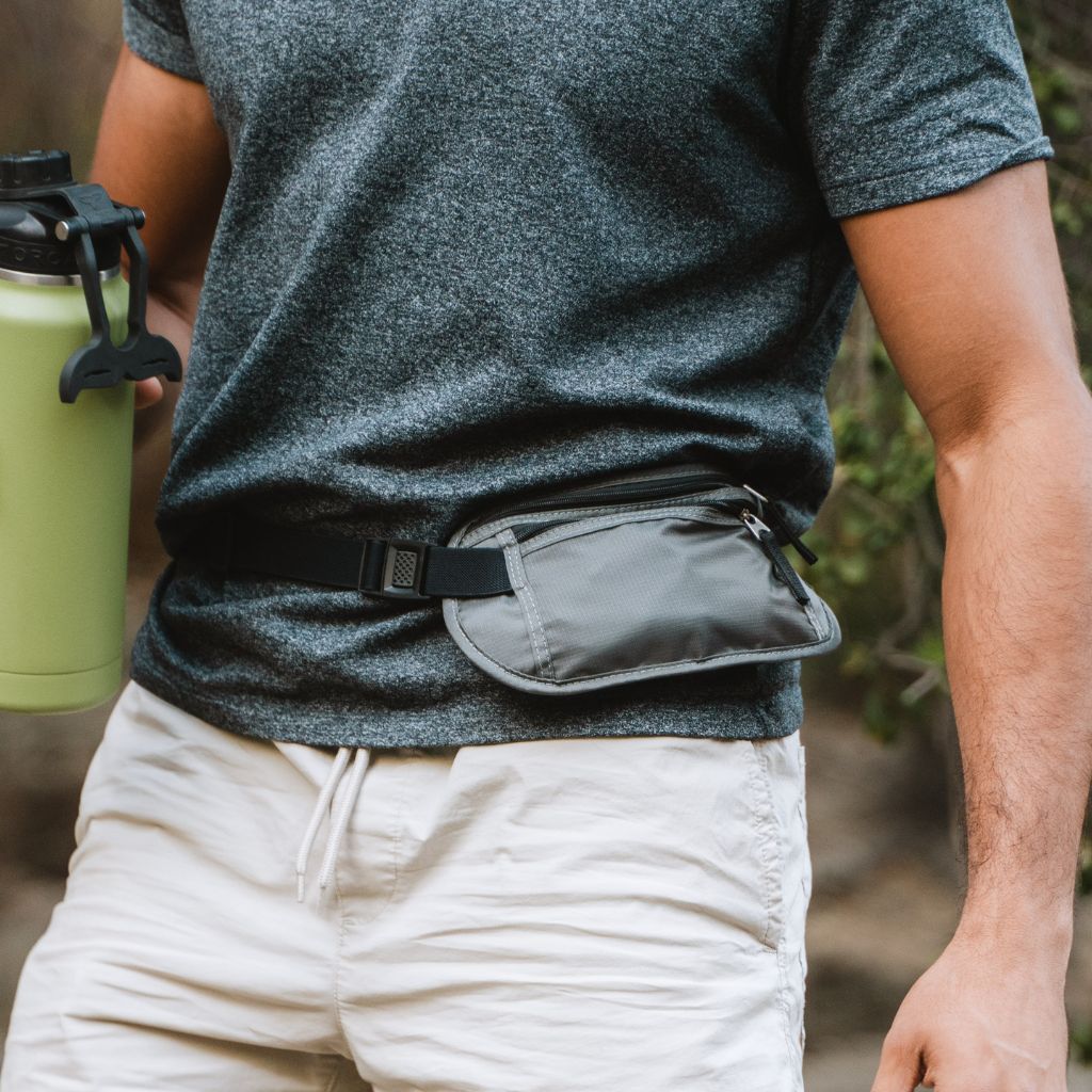 Trail Ready Survival Kit hip bag on man's waist while holding water bottle