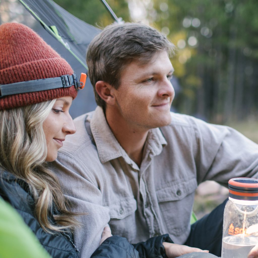 Venture Rechargeable Headlamp on woman's head seated next to man in tent entrance