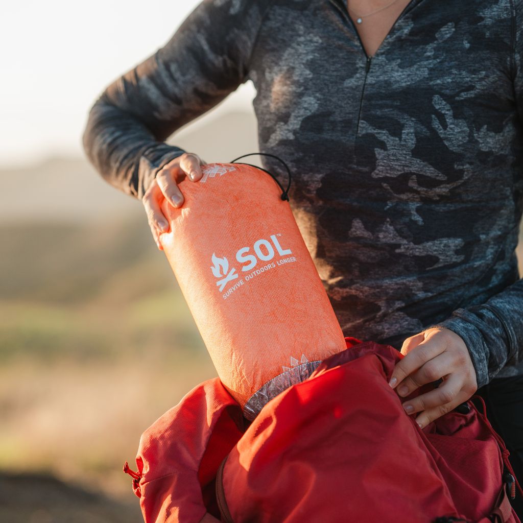 Escape Insulated Poncho removing poncho in sleeve from backpack