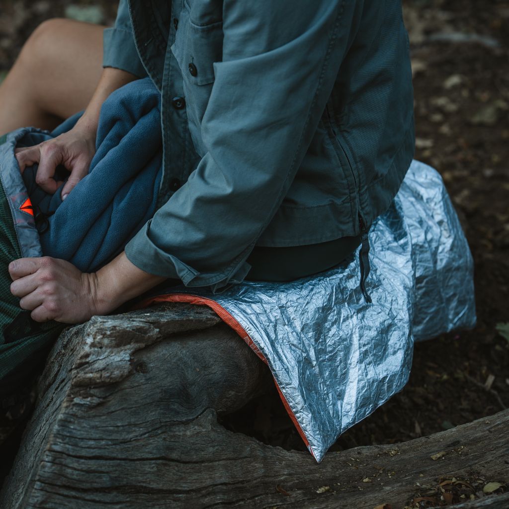 Escape Insulated Trail Seat person sitting on while getting in sleeping bag
