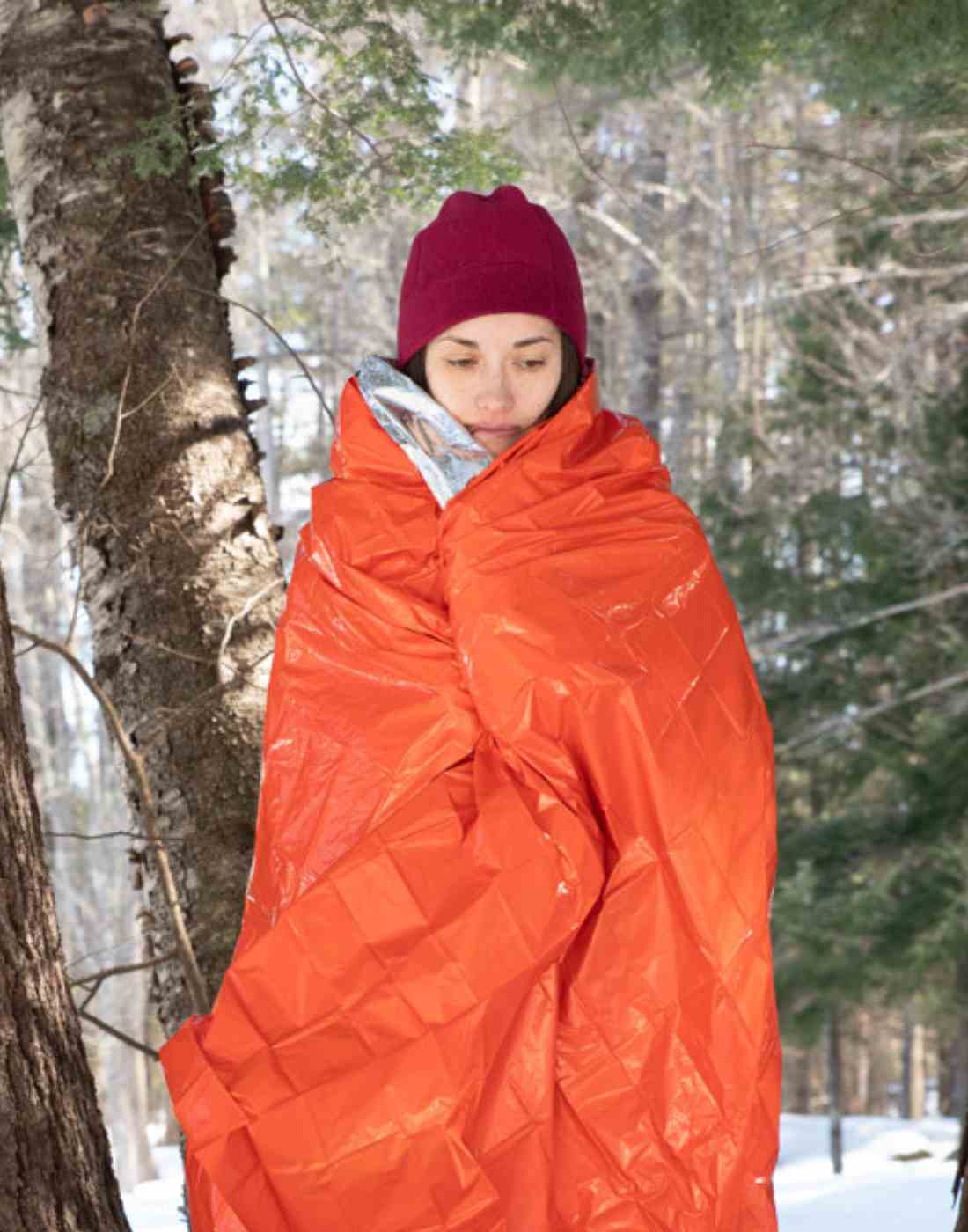 Woman in Snowy Landscape Wrapped in SOL Emergency Blanket