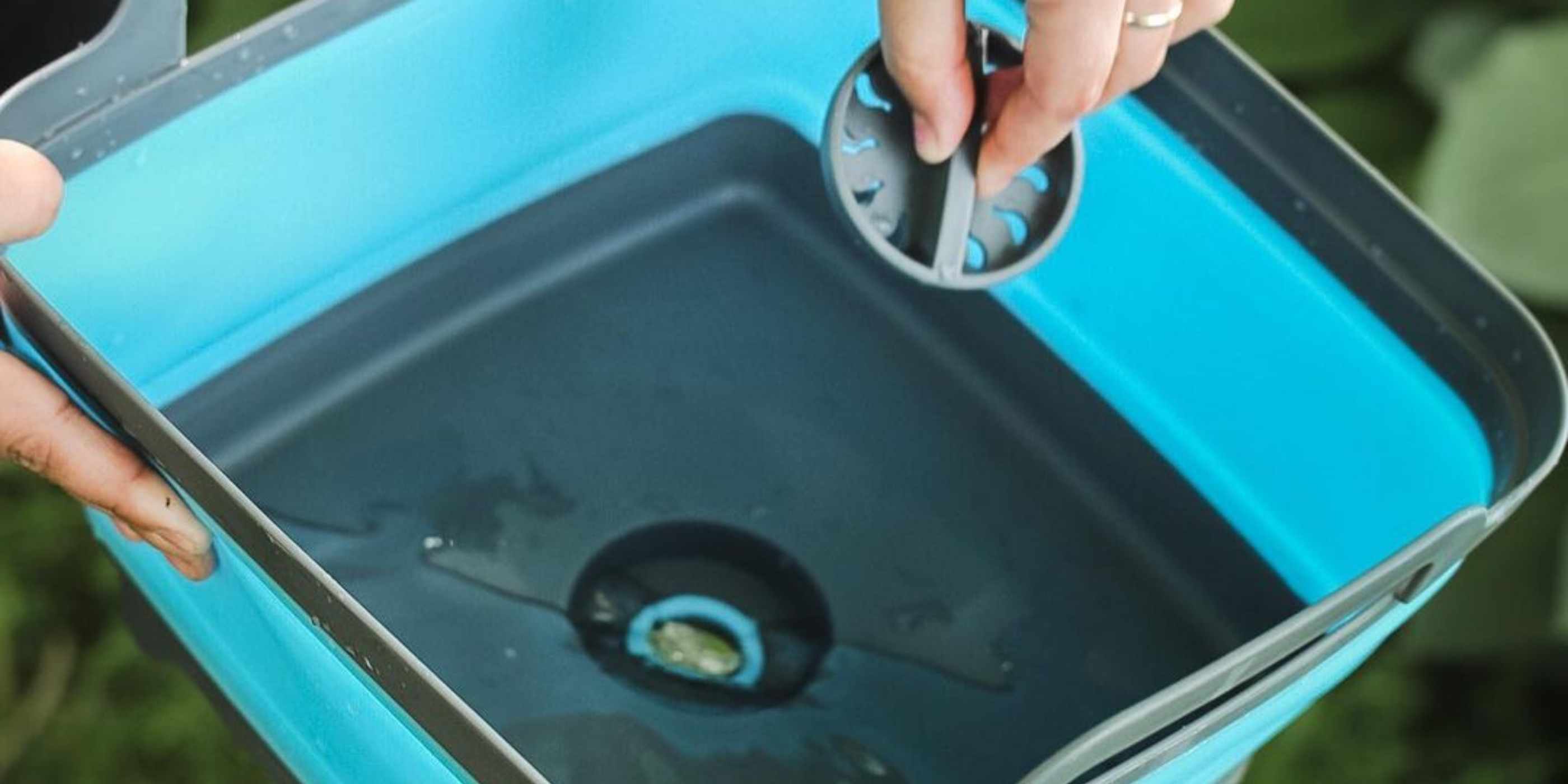 Pulling Drain Out of Blue and Gray Flat Pack Collapsible Sink 8L