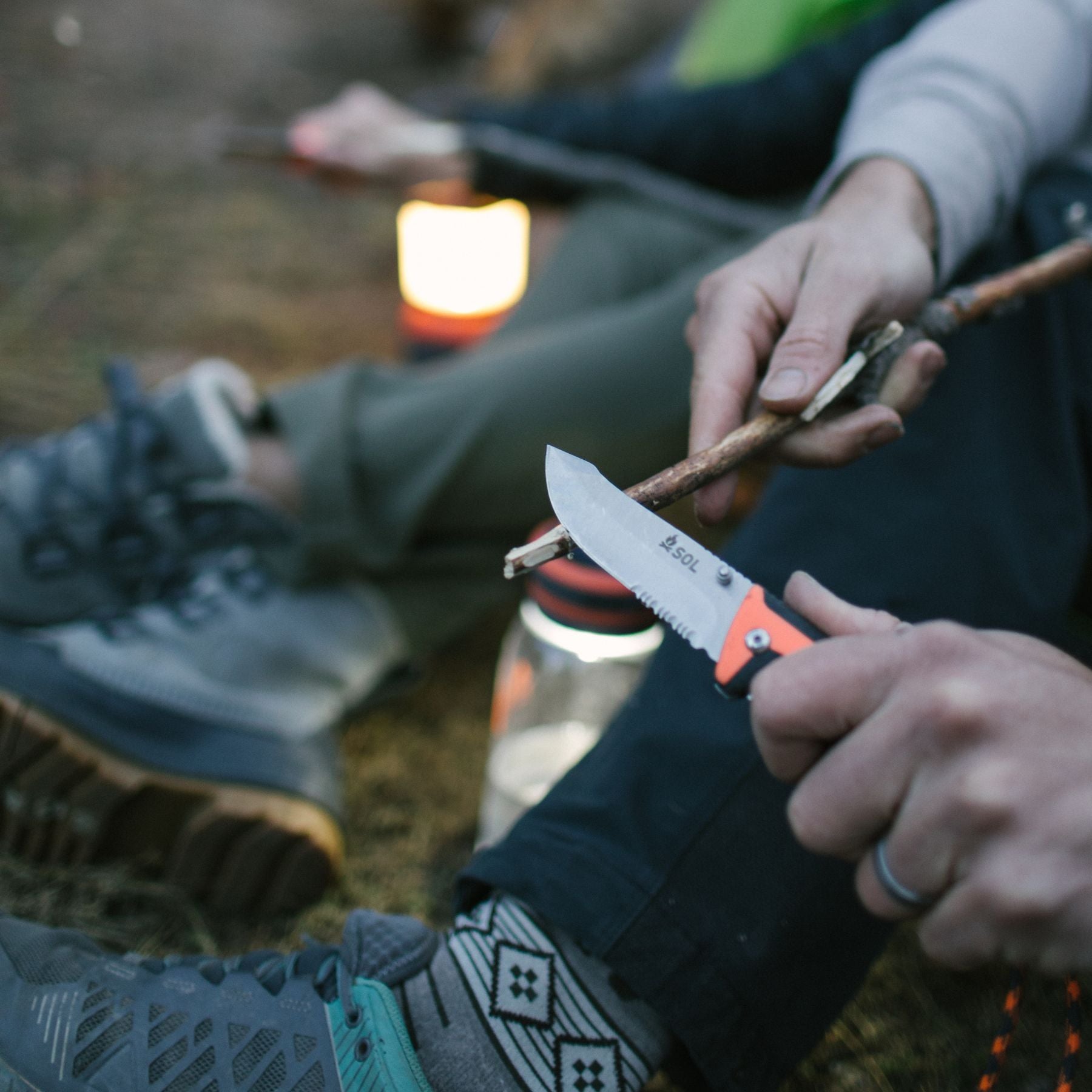 Person Using SOL Stoke Folding Knife to Shave Twig