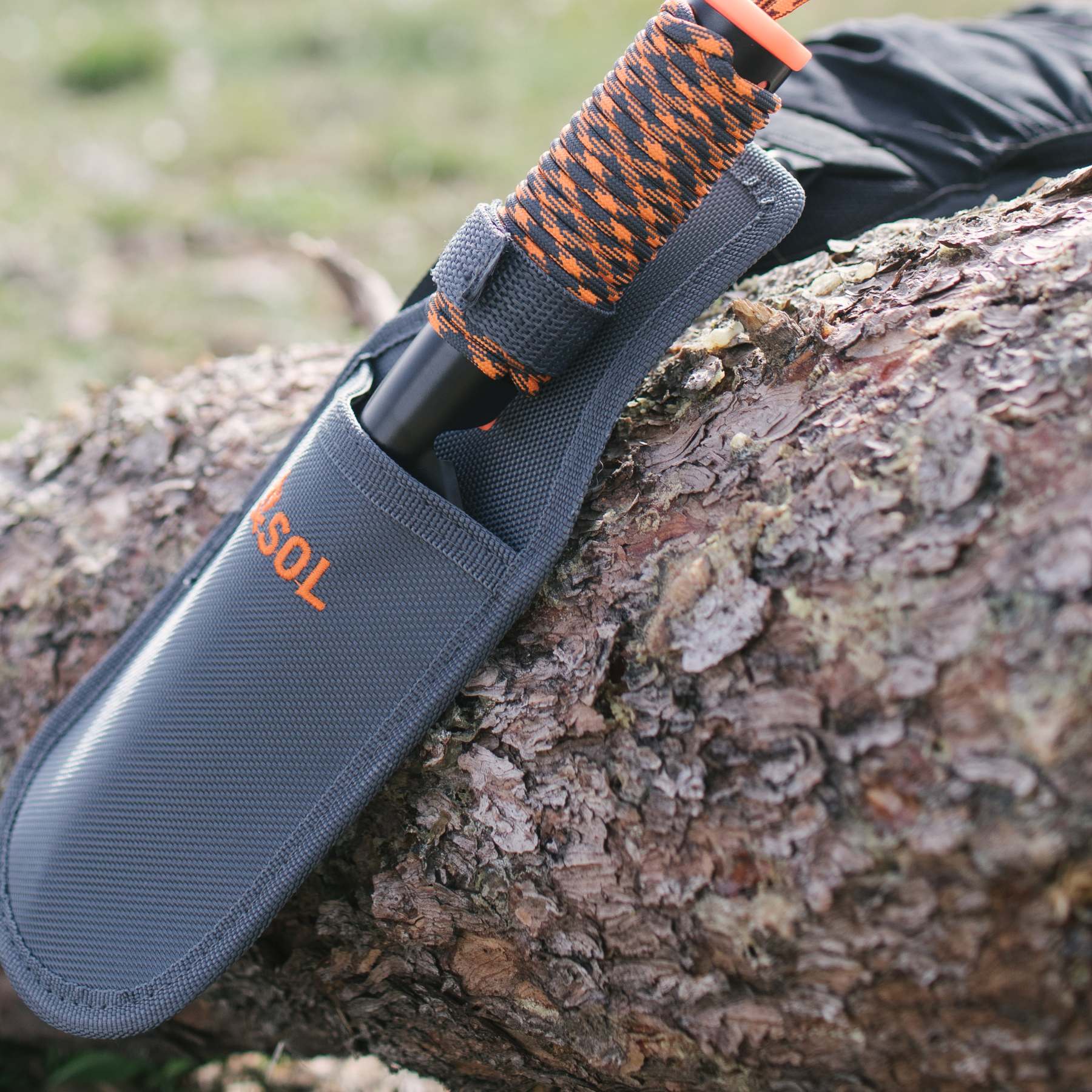 SOL Stoke Shovel in Holster Lying on a Tree