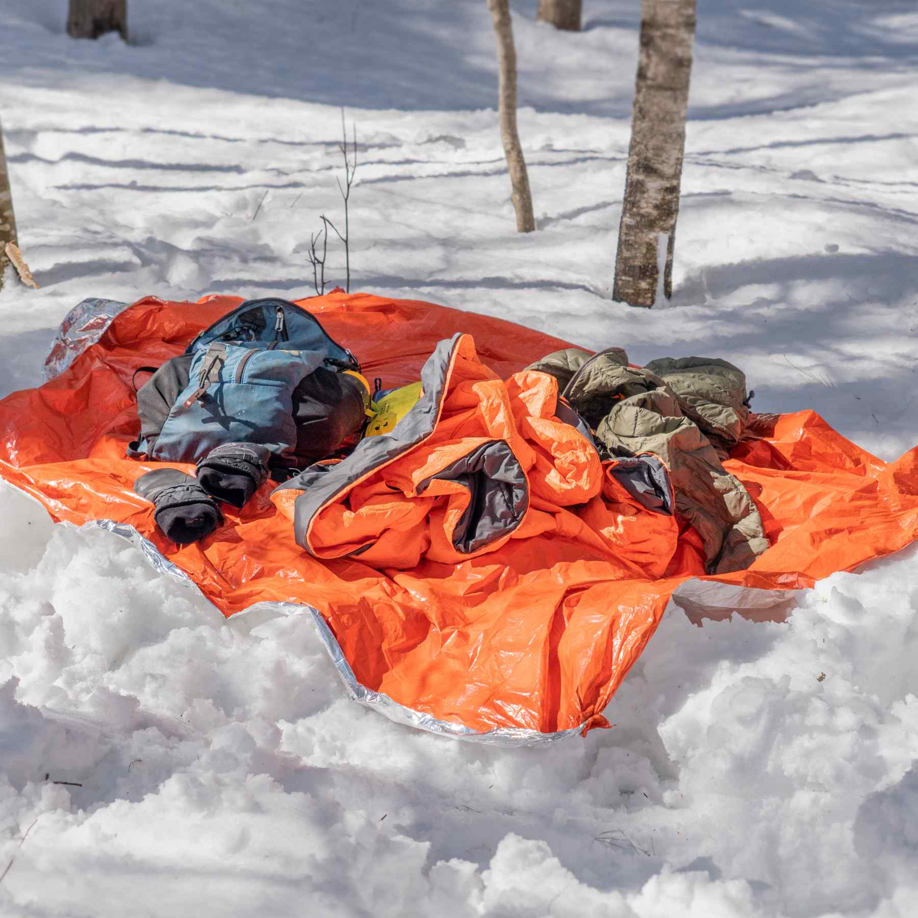 Emergency Blanket being used as tarp for gear on snow