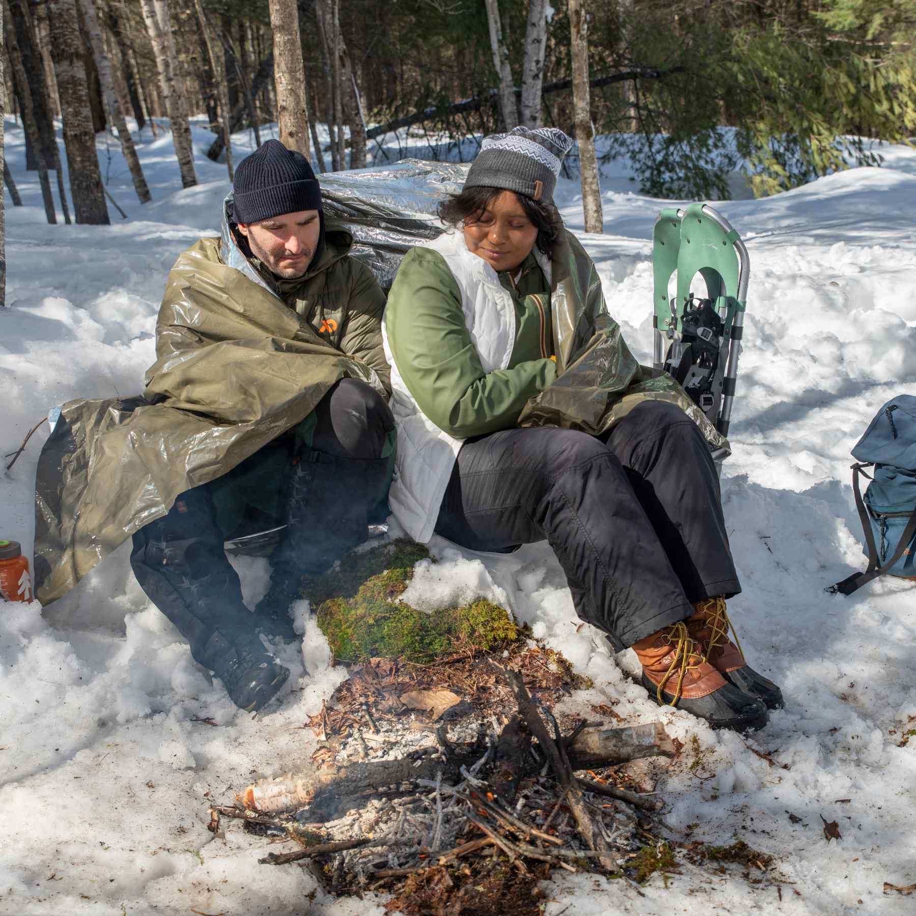 Heavy Duty Emergency Blanket man wrapped in blanket seated next to woman at campfire