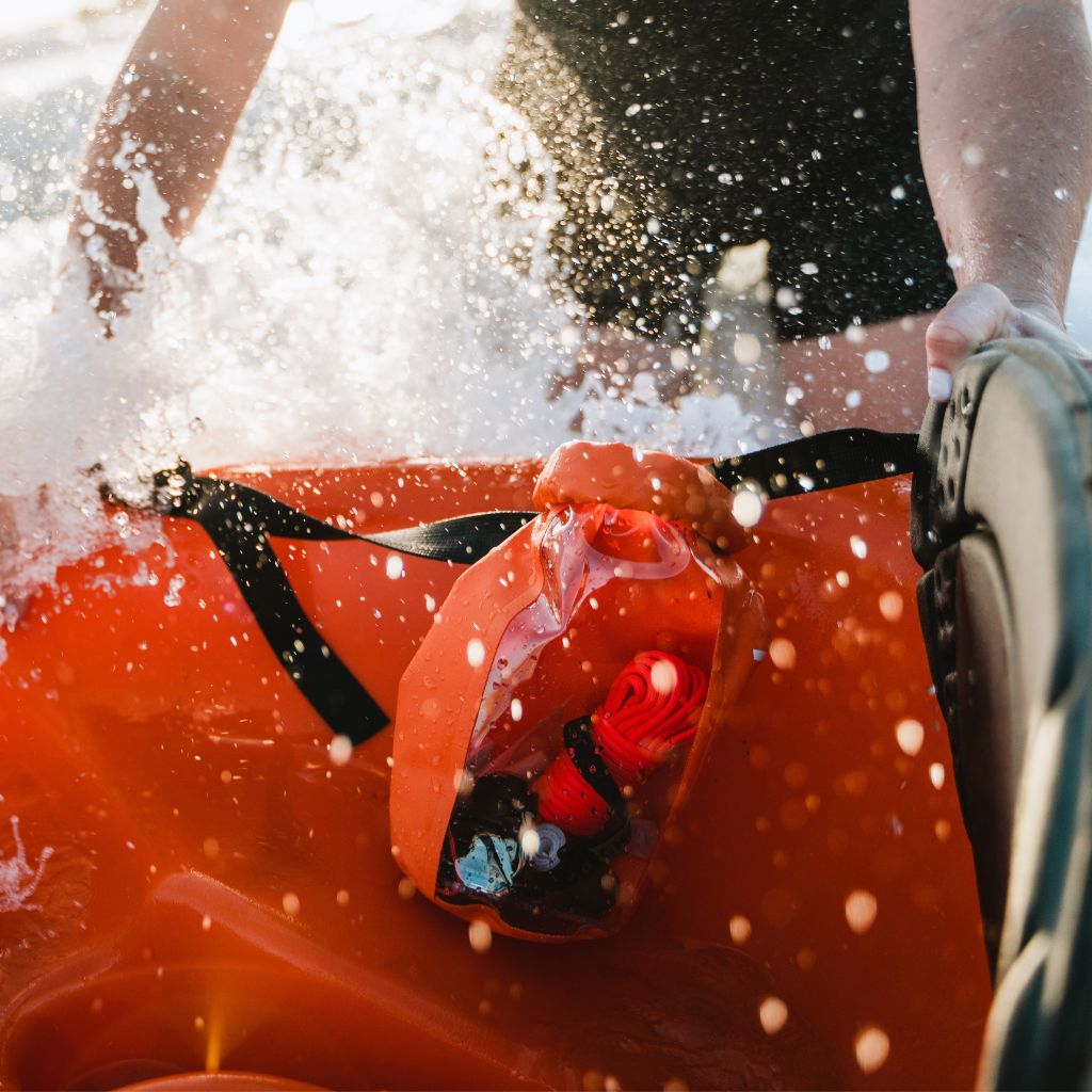 Adventure Ready Survival Kit on kayak with water splashing over it