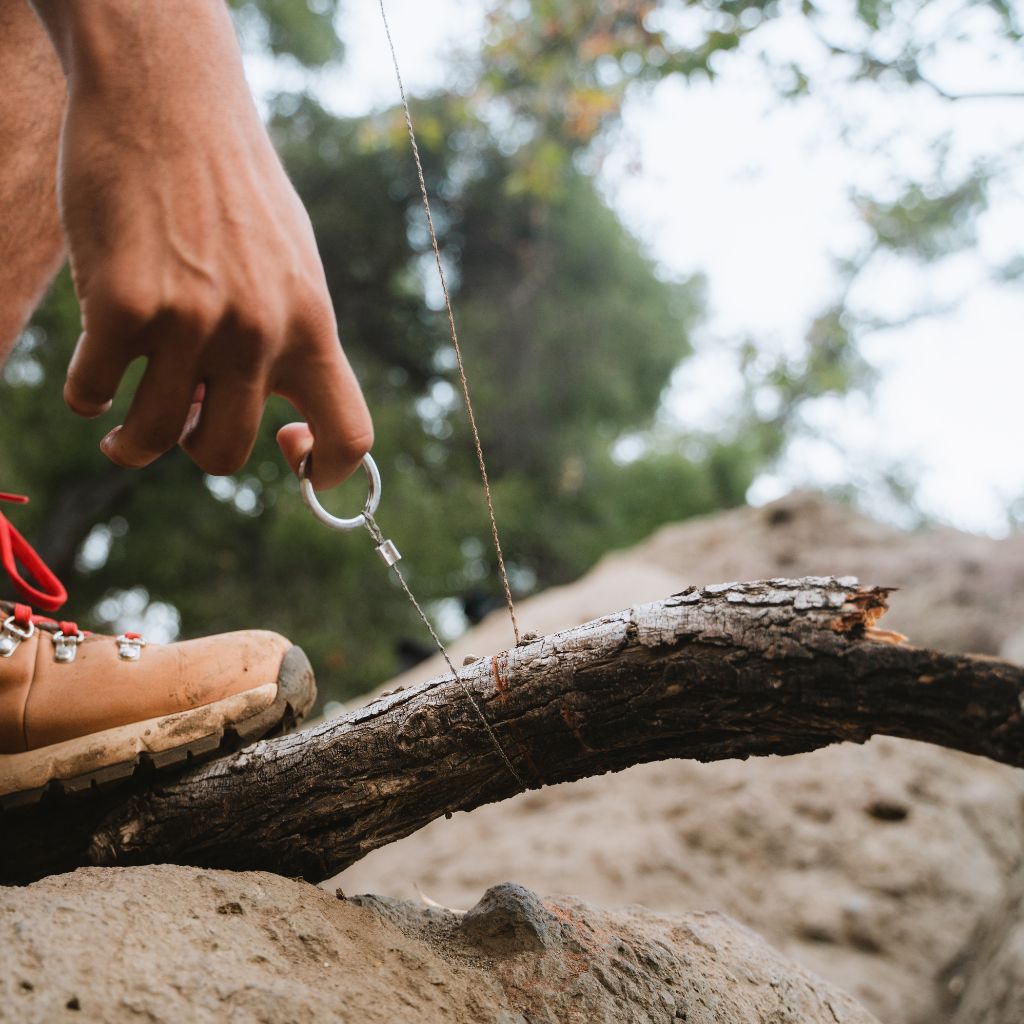 Camp Ready Survival Kit using saw on downed tree limb