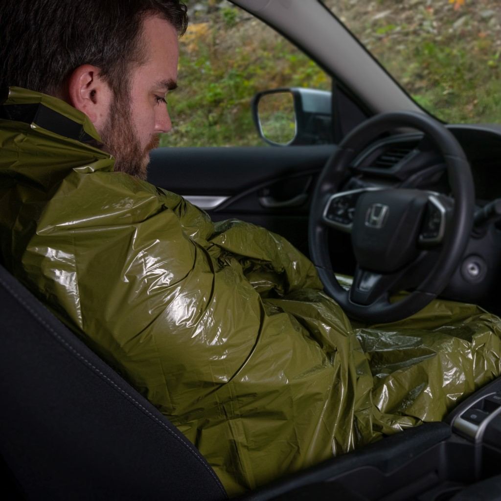 Emergency Bivvy with Rescue Whistle - OD Green man in car wrapped in bivvy