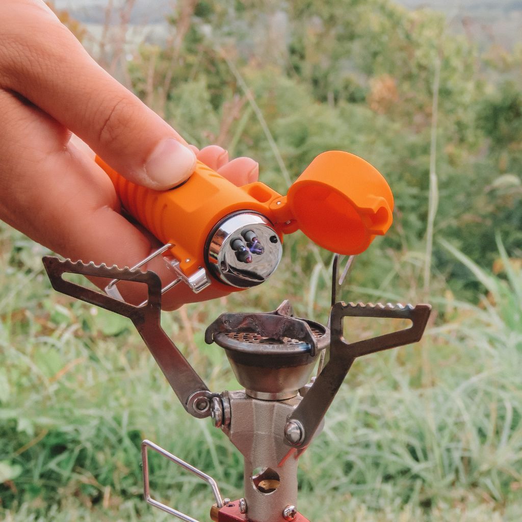 Fire Lite Fuel-Free Lighter lighting camp stove with grassy background
