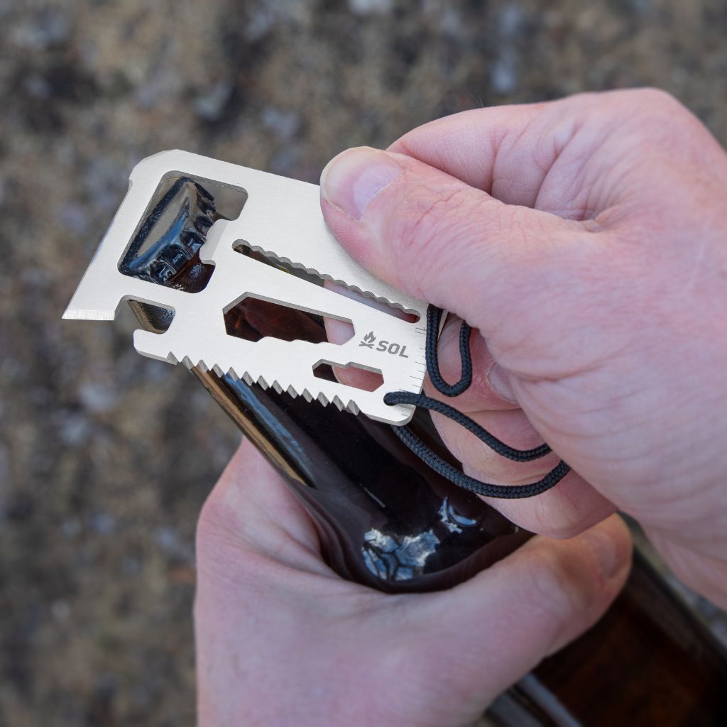 PackIt Survival Card Tool being used as a bottle opener