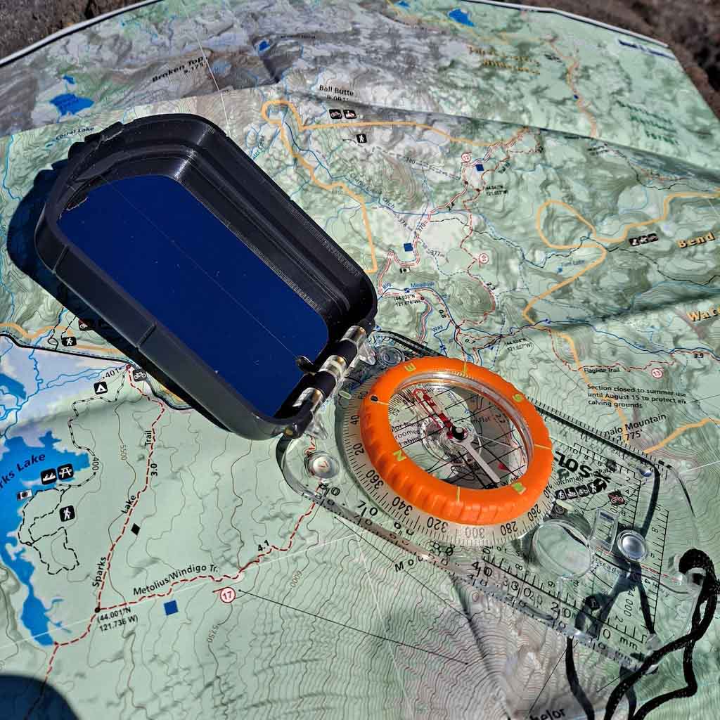 Sighting Compass with Mirror sitting on map